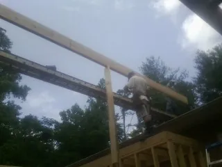Carpenter setting a ridge beam over a new addition frame — Ice Dam Removal by Roofing Brothers in Britton