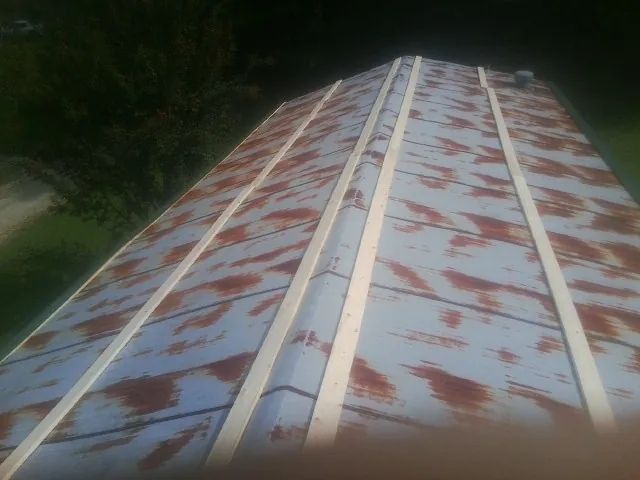 Rusted metal roof panels with new wood purlins before replacement — Storm Damage Roof Repair in Britton by Roofing Brothers